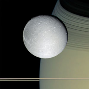 <p>Der Saturnmond Dione – im Hintergrund der Saturn mit Ringebene</p>
